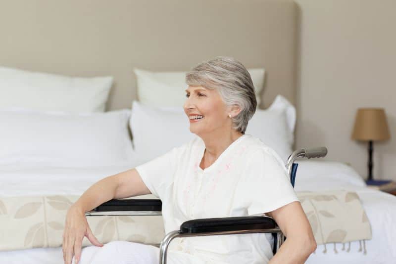elderly woman in bedroom in wheelchair