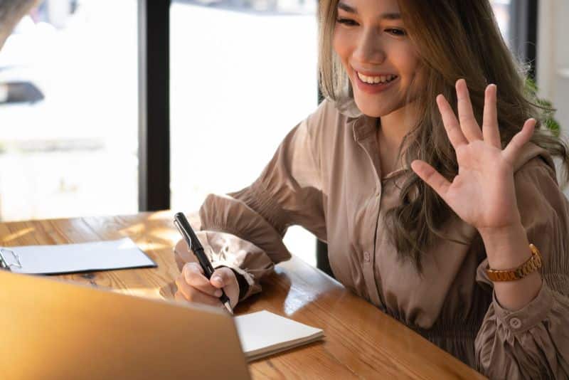 teacher waving hello to online students