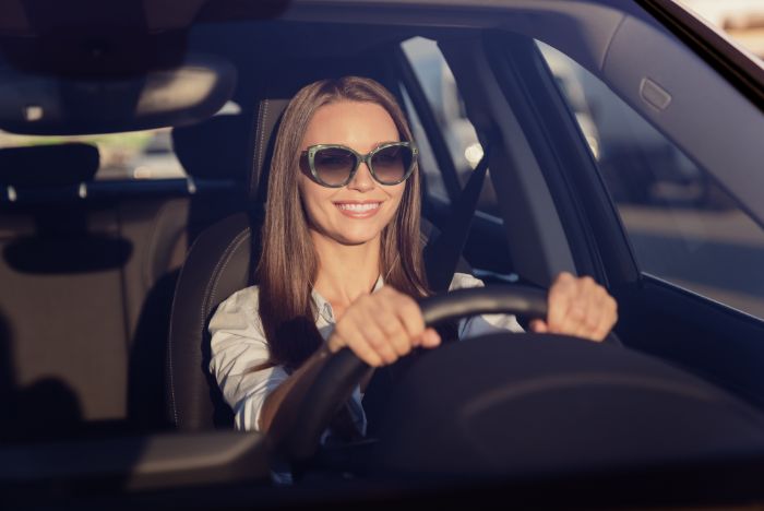 woman in sunglasses in car smiling