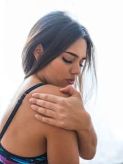 woman rubbing shoulder that is painful