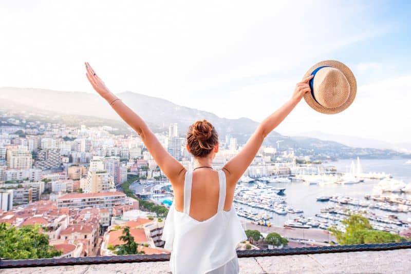 woman with outstretched arms traveling in monaco