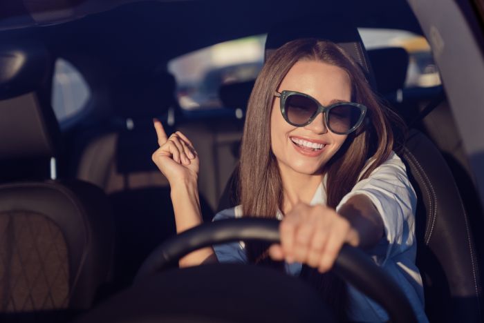 brunette in car smiling and pointing