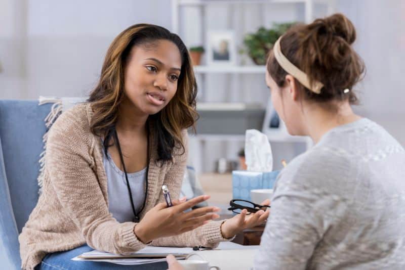 woman speaking with a counselor for help