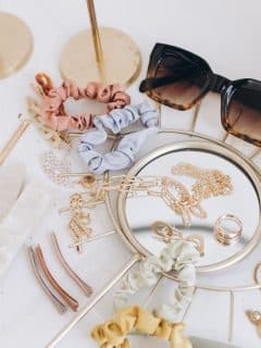 sunglasses, jewelry, and other accessories on white table