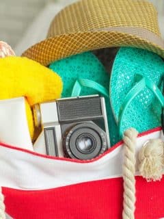 beach bag with sandals, camera, and other accessories