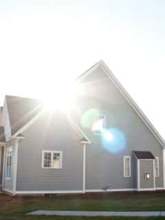 new home build with gray siding - sunlight reflecting off lens