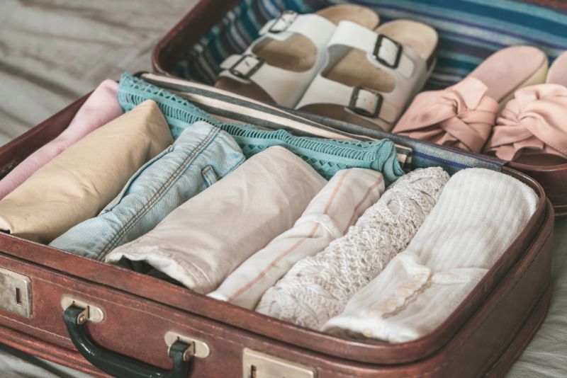 clothes rolled and packed into a suitcase