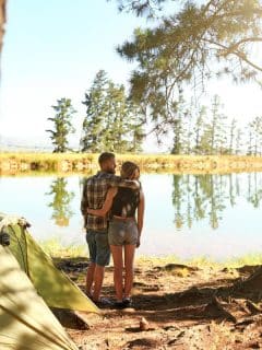couple with arms around each other overlooking a lake