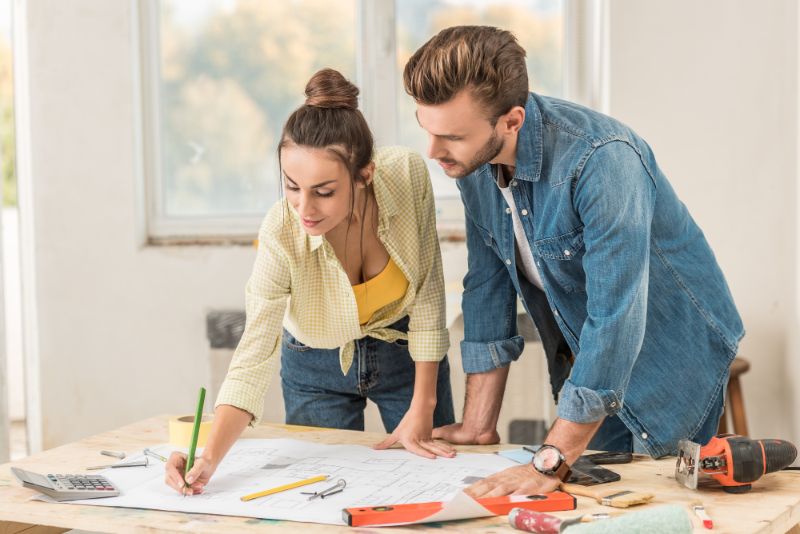 couple looking at blueprints for renovation