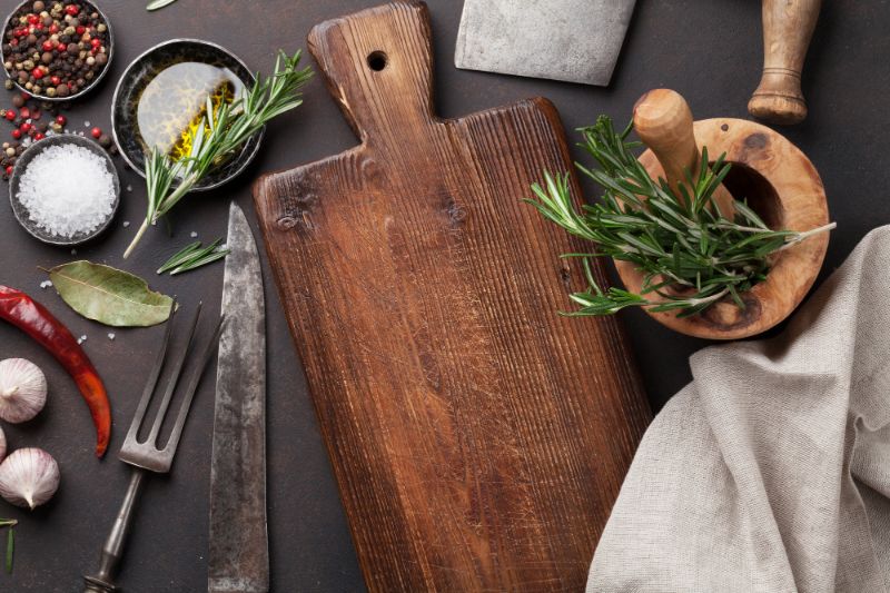 cutting board surrounded by spices