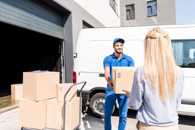 delivery man handing package to woman