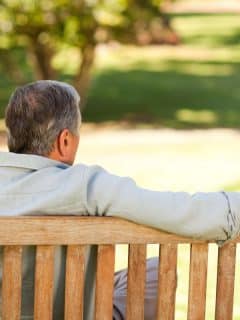 elderly man sitting on a bench outdoors