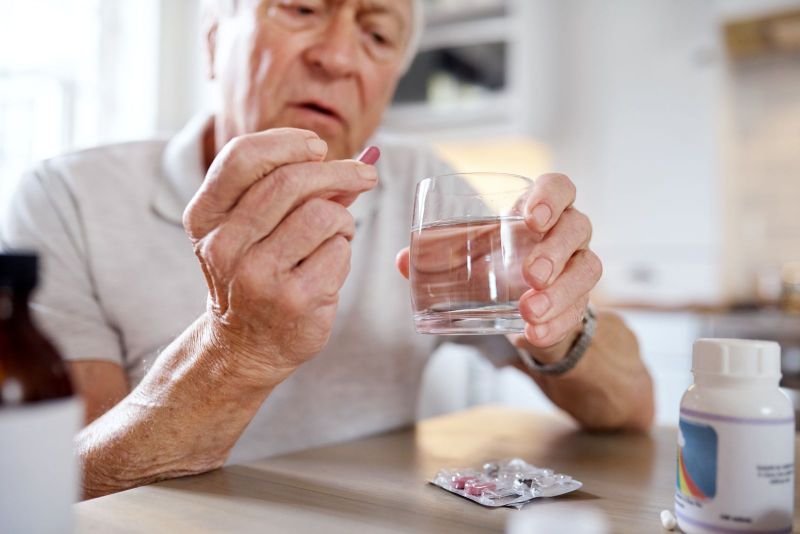 elderly man taking vitamins