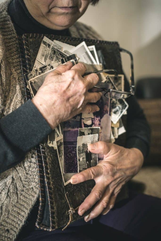 elderly woman hugging old photos