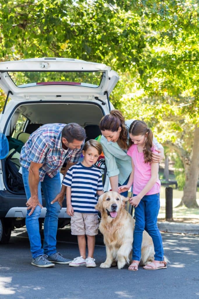 family with dog before road trip