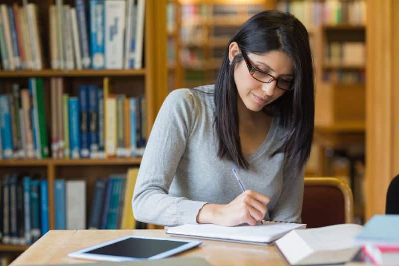 dark haired female college student studying in library