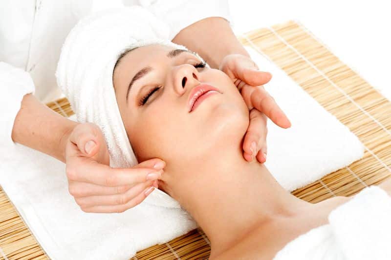 woman in spa receiving a facial massage