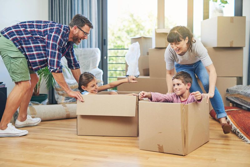 parents pushing kids around in boxes on move-in day