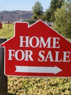 home for sale sign by side of road