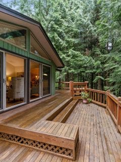 home with pretty deck surrounded by trees