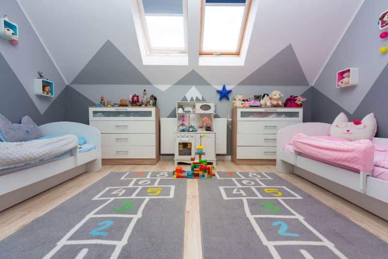 vaulted ceiling in child's bedroom with painted mountain scene extending from walls to ceiling
