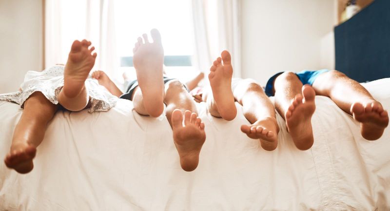 kids' feet dangling over bed