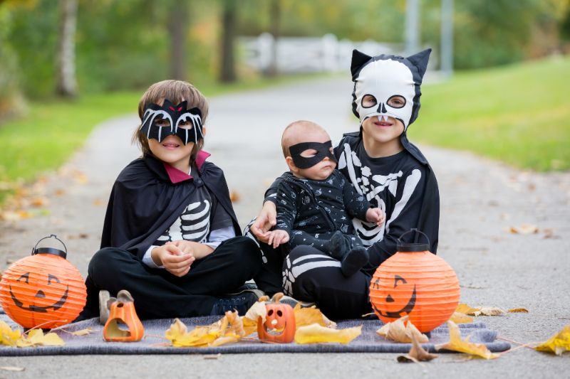 three children in halloween costumes with halloween decorations
