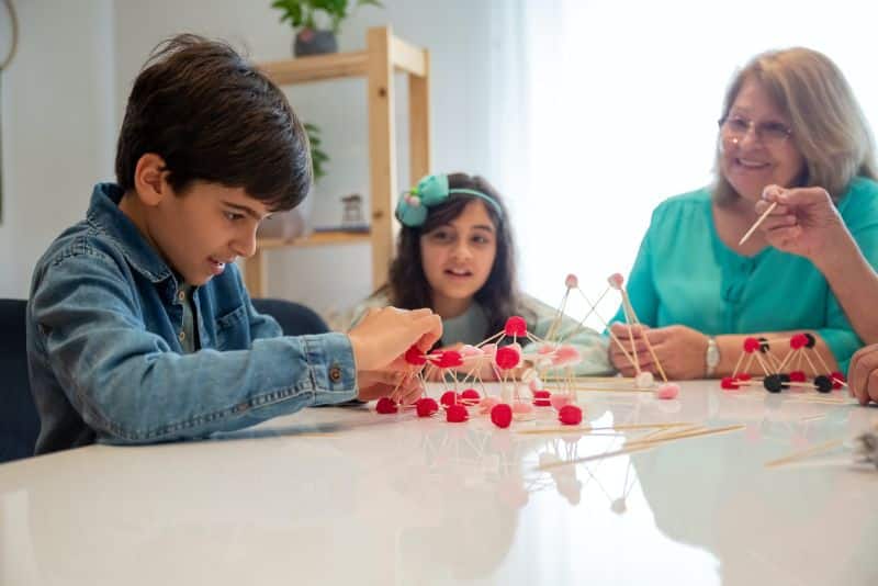 kids working on STEM experiment with grandmother