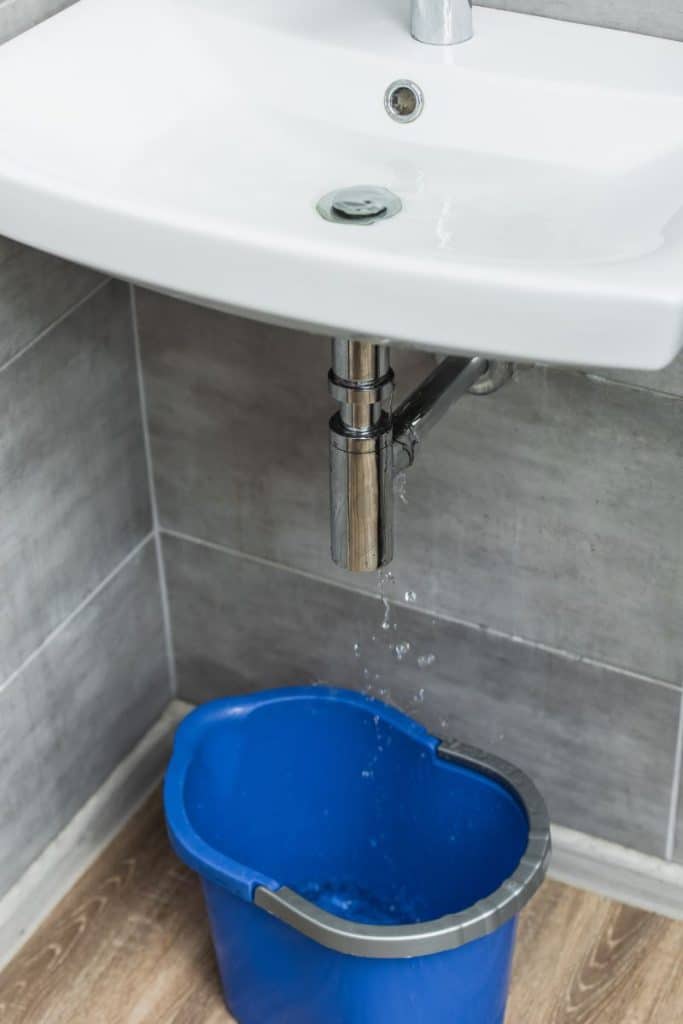 sink leaking into a blue bucket