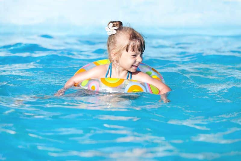 little girl in float in swimming pool
