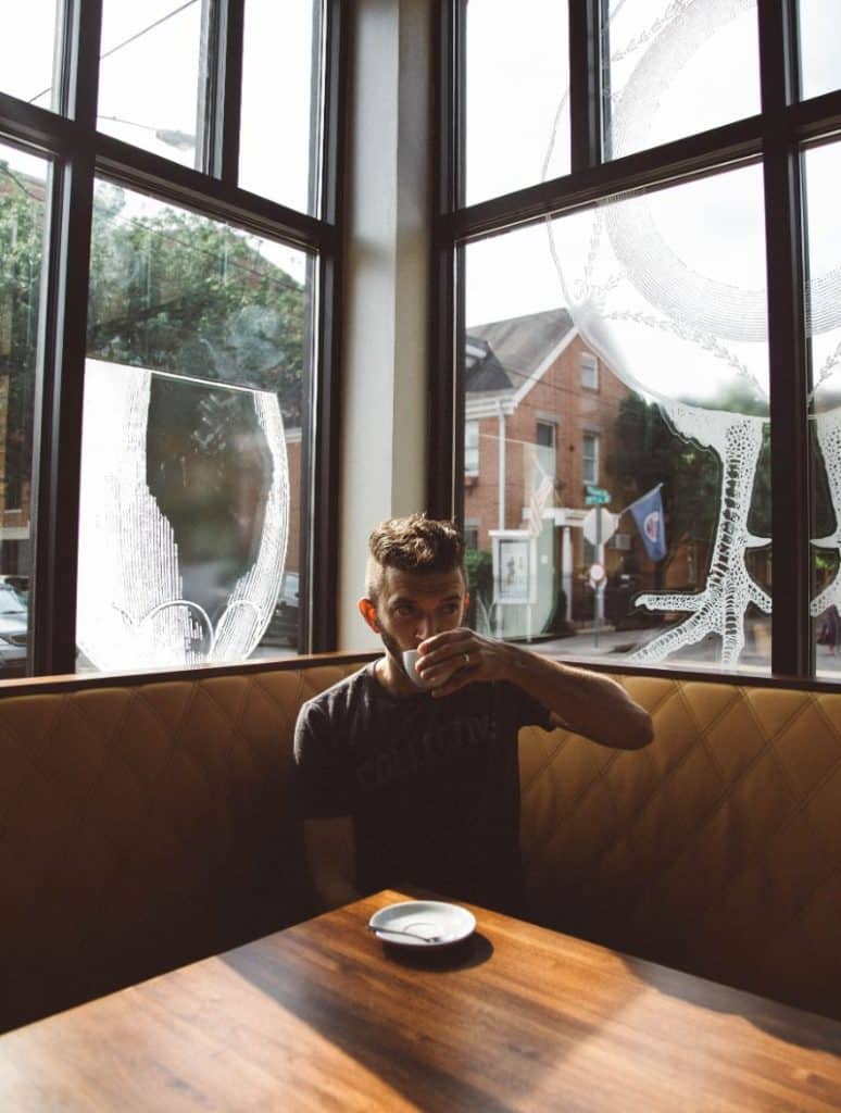 man sitting in booth at coffee shop