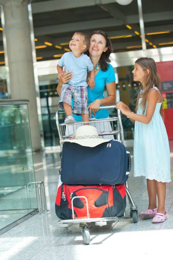 mother and children with their luggage at an airport