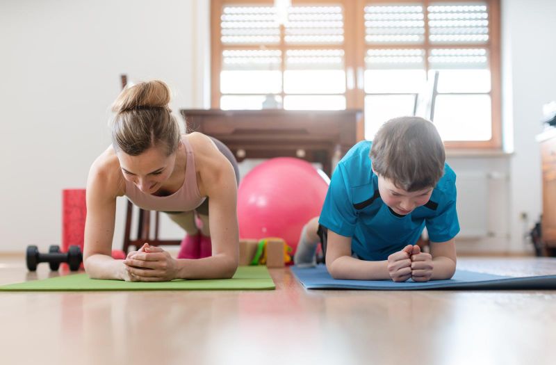 mom and son doing planks on exercise mats