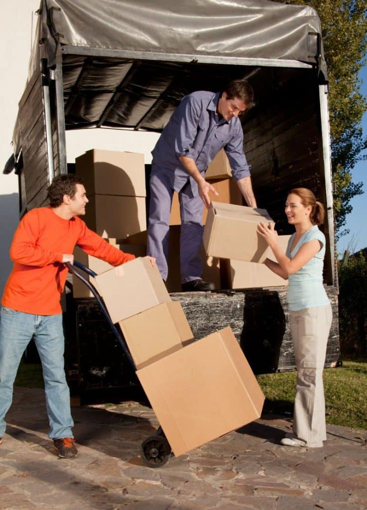 couple and mover loading boxes into a moving van