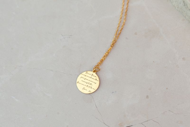 gold pendant on chain with inscription