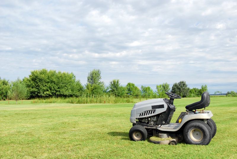 riding lawn mower on grass, cloudy sky