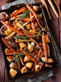 roasted vegetables in sheet pan on dark wood background