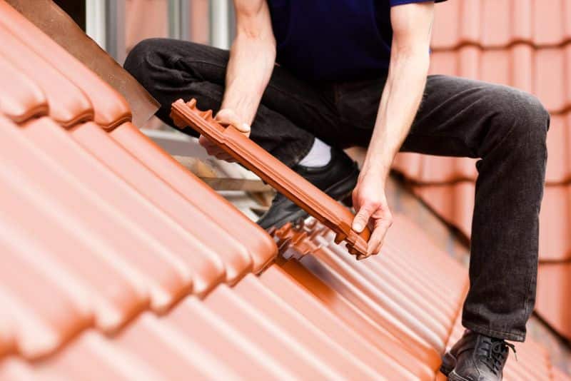worker installing roof tiles