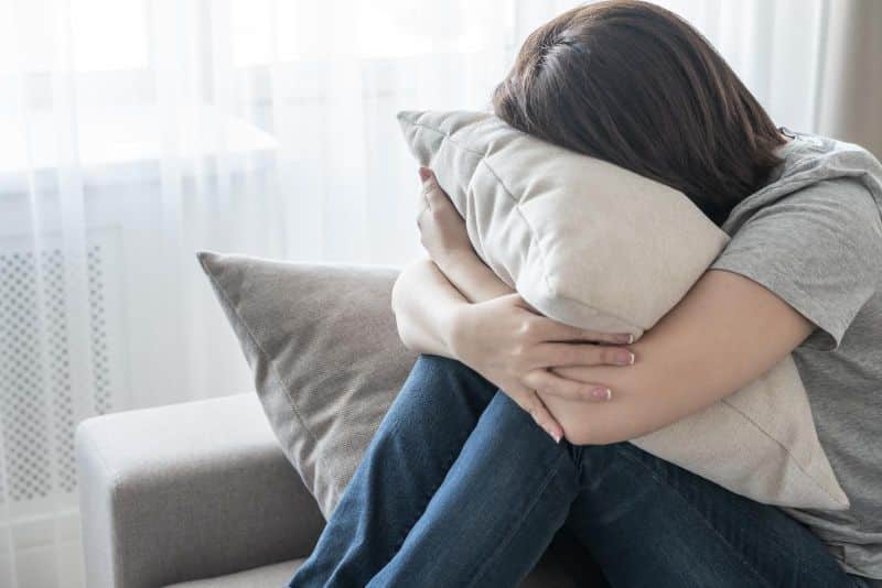 sad female hugging pillow