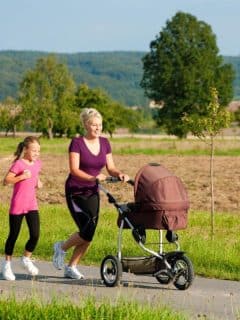 mom jogging with baby stroller and older child running beside her