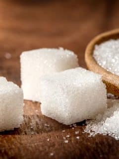 close up of sugar cubes on wood background