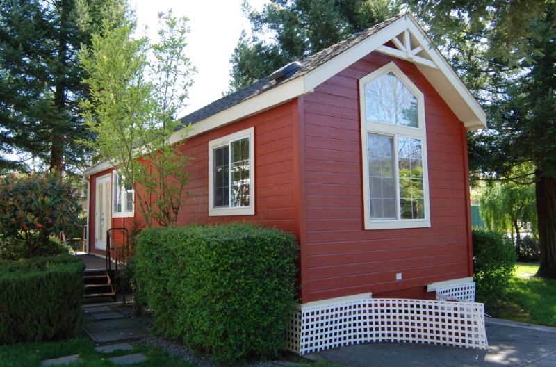 tiny red house with shrubs