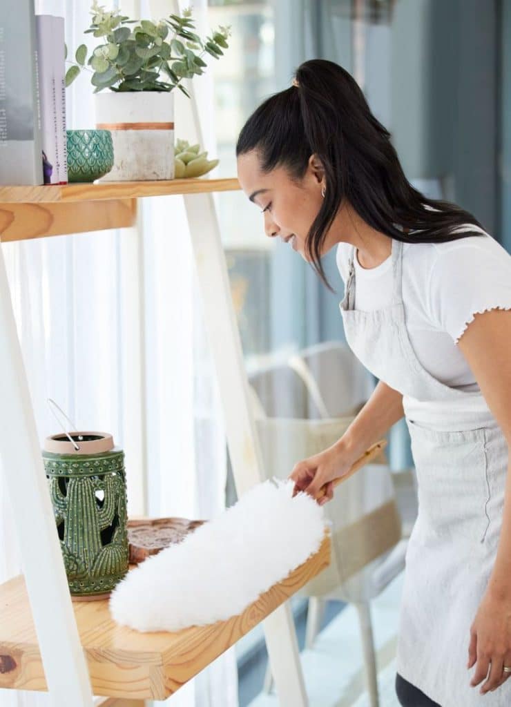 woman dusting a small table