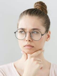 a woman in glasses in deep thought