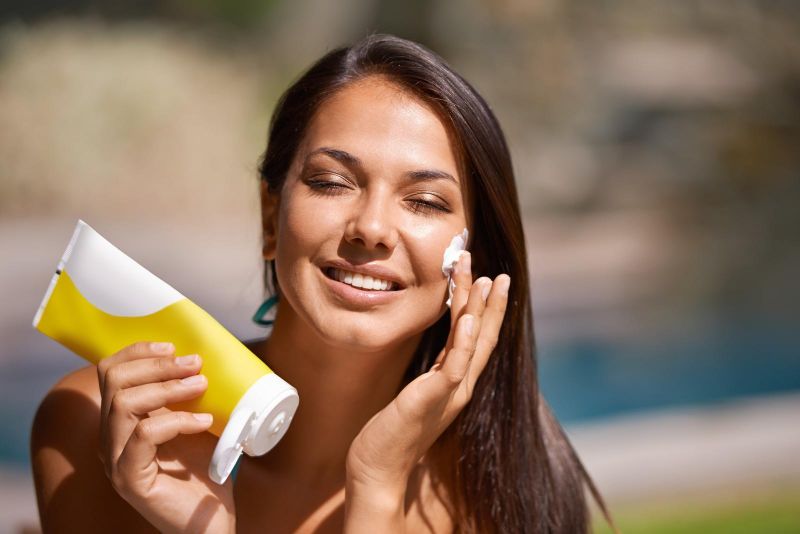 woman applying sunscreen to her face