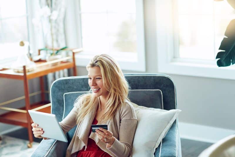 woman smiling and shopping online with credit card