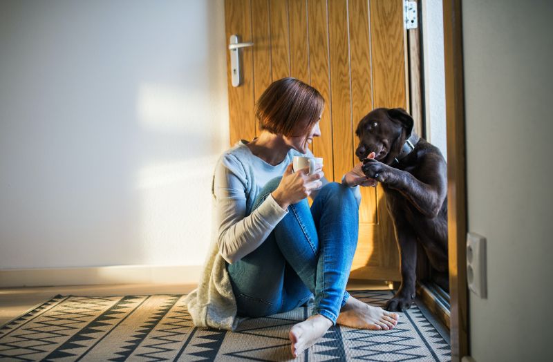 woman and dog by open front door