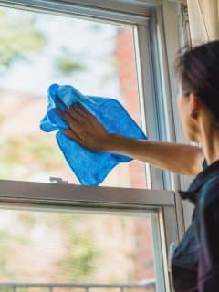 woman wiping windows with a cloth