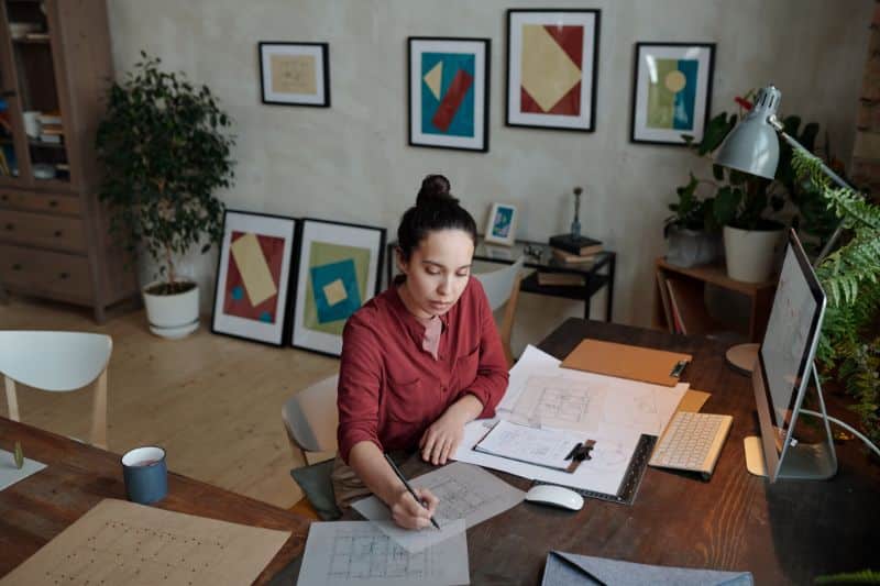 woman working at desk with wall art in background