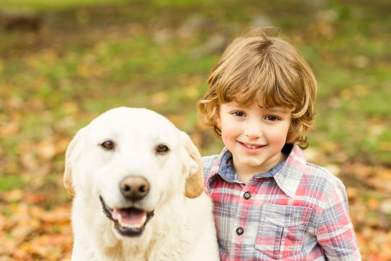 smiling boy with dog outdoors